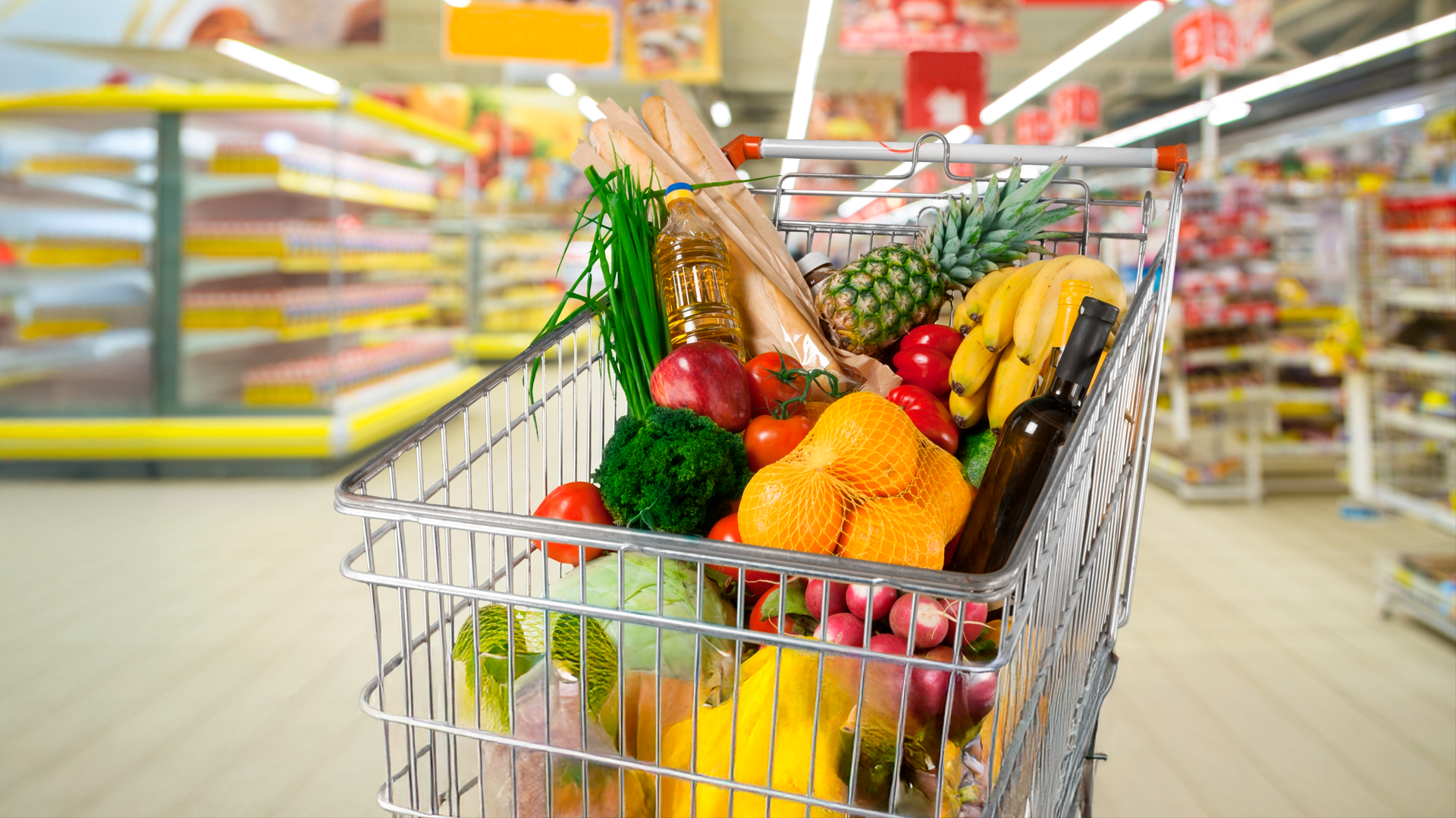 Primer plano de carro de compras lleno en sección de frutas y verduras de un supermercado. IPC. FEB 2025.