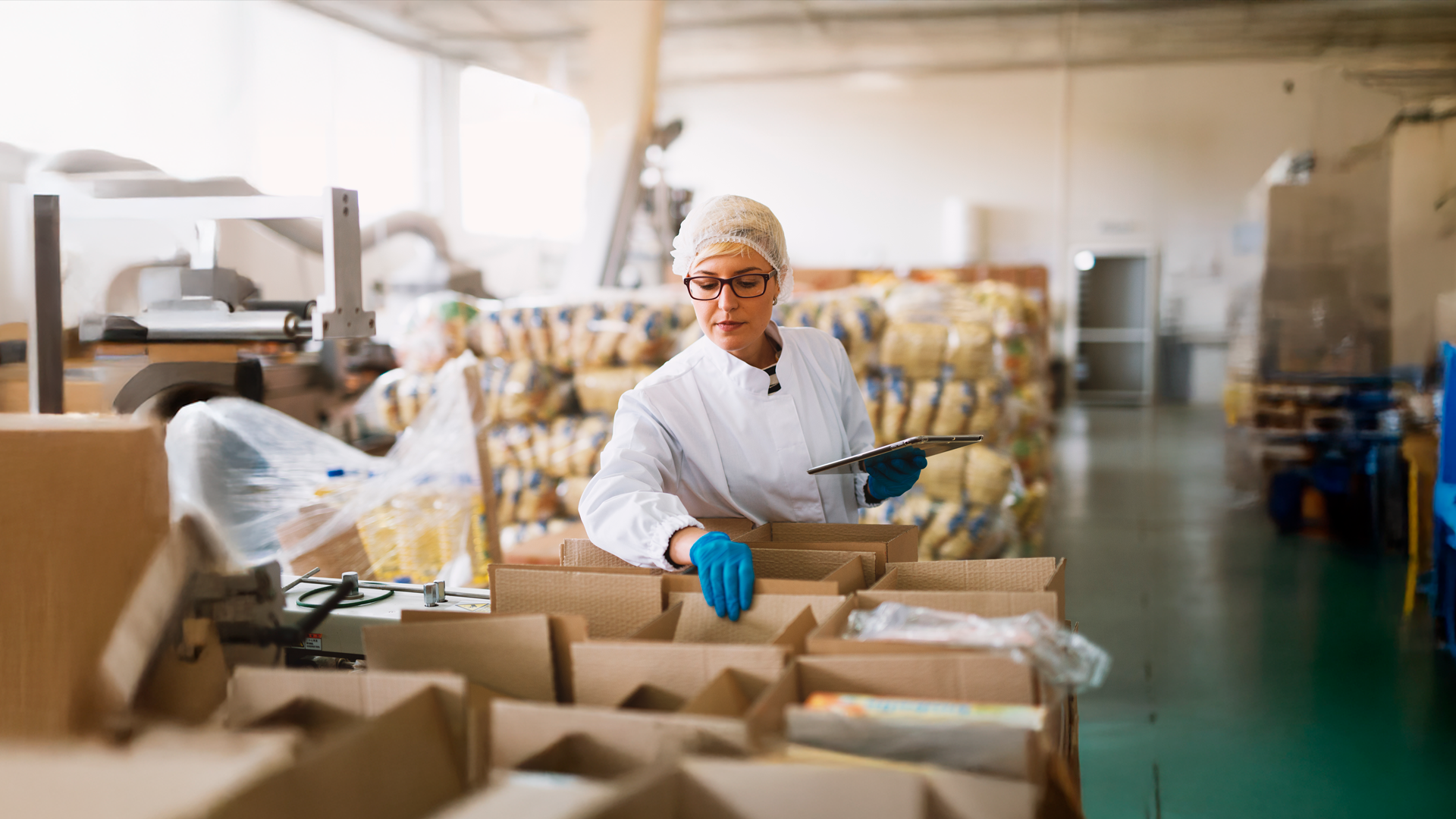 Trabajadora de la industria manufacturera revisa inventario de producto almacenado en cajas de cartón. ECE. TRIM DEF2024-2025.